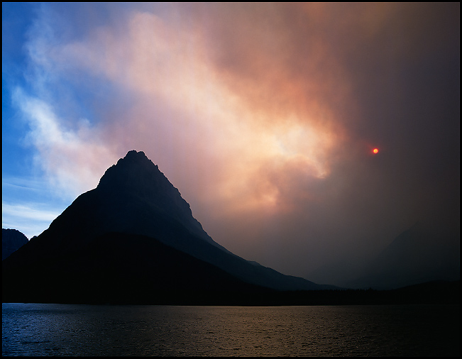 Grinnell Point with blue sky and smoke from the Trapper Creek forest fire, Glacier National Park, Montana, July